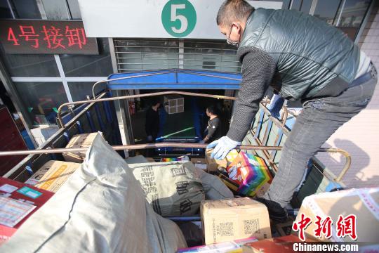 資料圖：工作人員正在給快遞包裹裝車。張?jiān)啤z